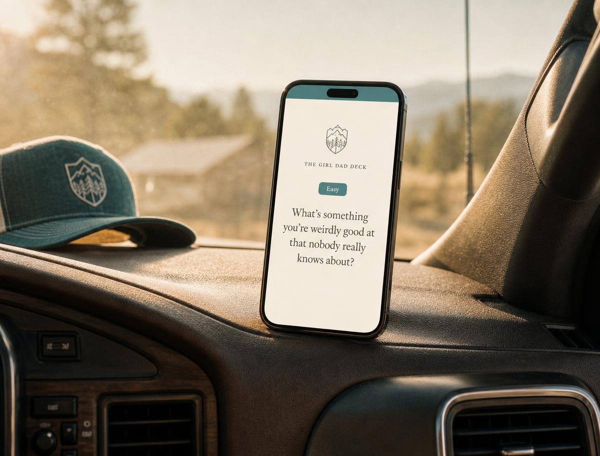 A phone held in one hand showing a single card, in a warm-lit car.